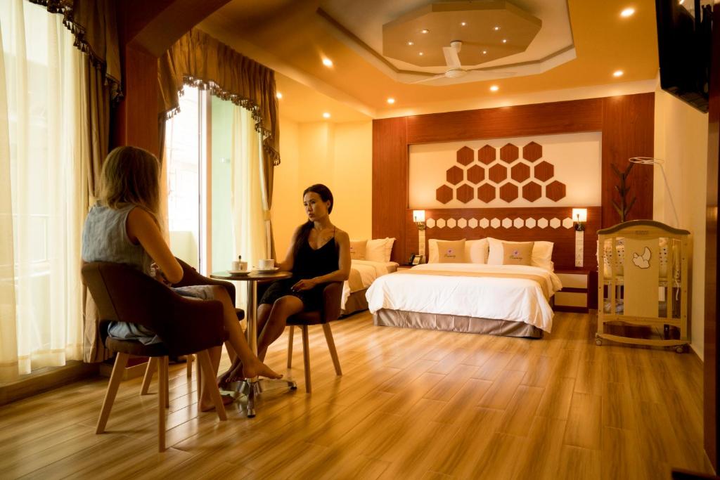 two women sitting at a table in a hotel room at Rosemary Boutique in Maafushi