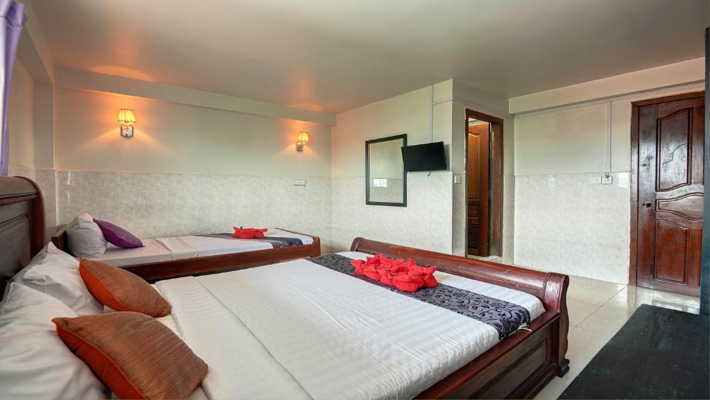 a bedroom with two beds with red flowers on them at Siem Reap Pub Hostel in Siem Reap