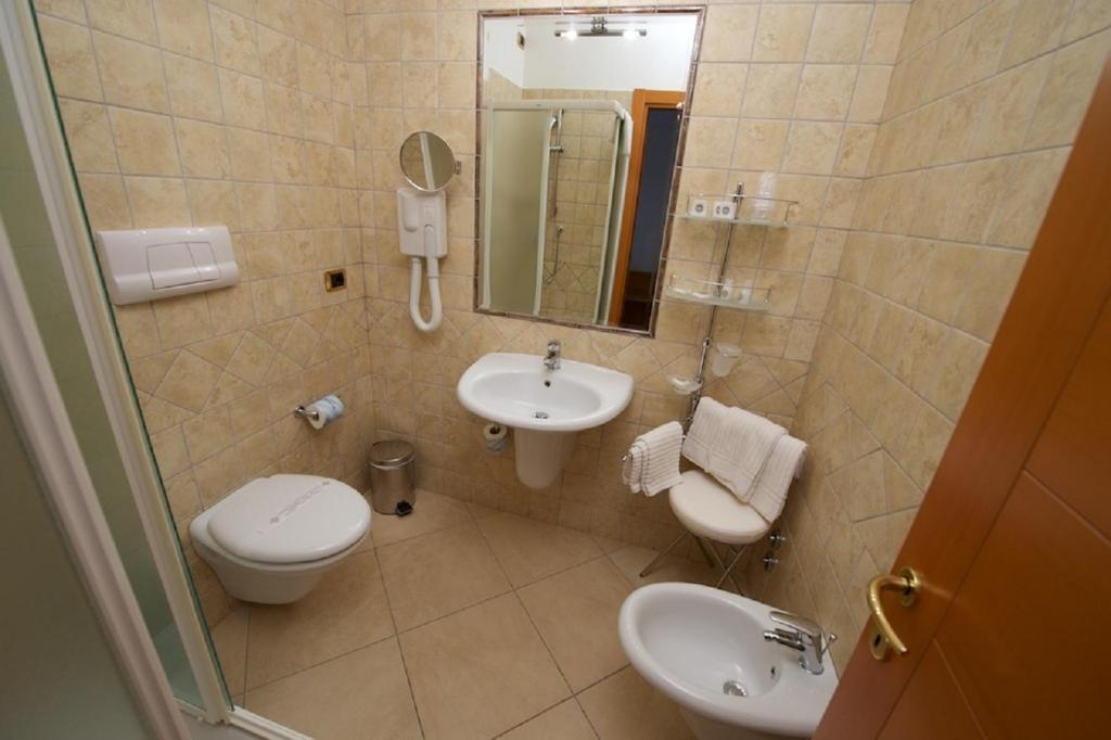 a bathroom with a sink and a toilet and a mirror at Hotel Portonuovo in Vieste