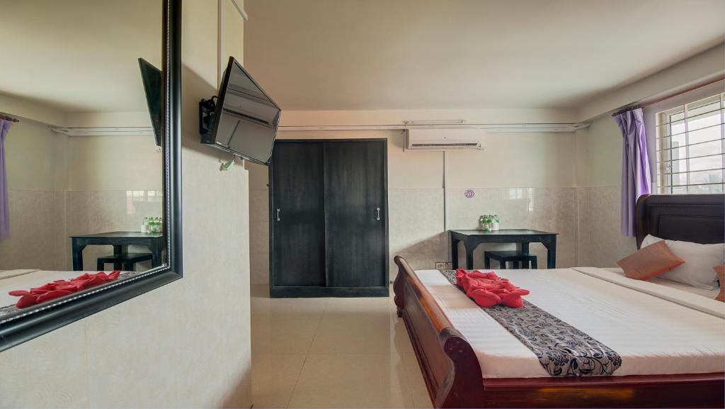a bedroom with a mirror and a bed with red roses at Siem Reap Pub Hostel in Siem Reap