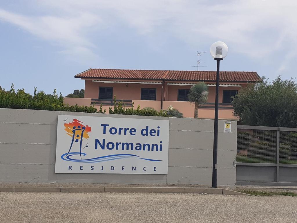 ein Schild an einer Wand vor einem Gebäude in der Unterkunft Torre dei Normanni in Marina di Sibari