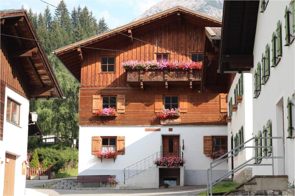 um edifício com caixas de flores nas janelas em Bergbauernhof Pabulariu em Boden