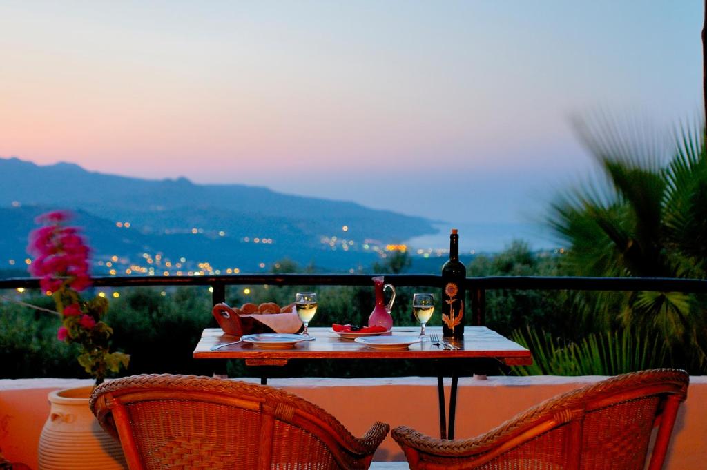 a table with a bottle of wine and two glasses at Elia Hotel & Spa in Áno Voúvai