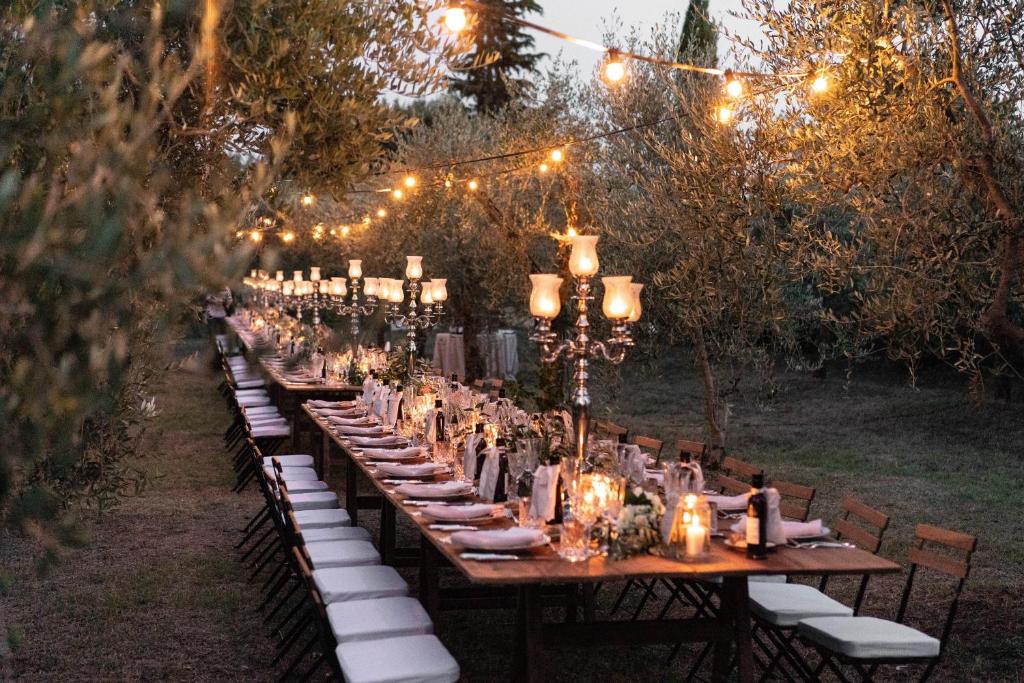 a long table with chairs and lights on it at Borgo Argiano in Castelnuovo Berardenga