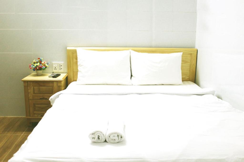 a bed with white sheets and white pillows at Saigon City Center Hostel in Ho Chi Minh City