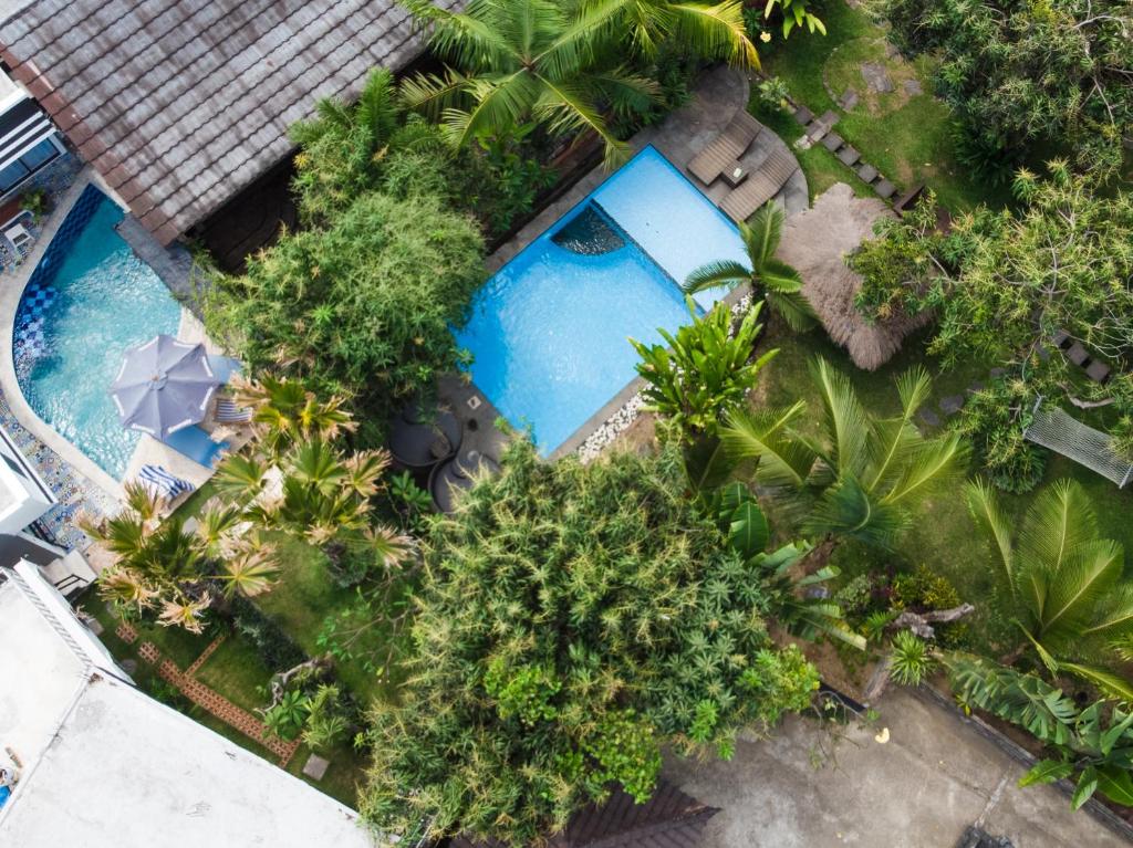 an overhead view of a swimming pool with trees at Vande Guest House in Canggu
