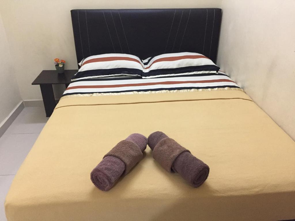 a bed with purple socks on it with a book at Ilhamku Inn in Kemaman