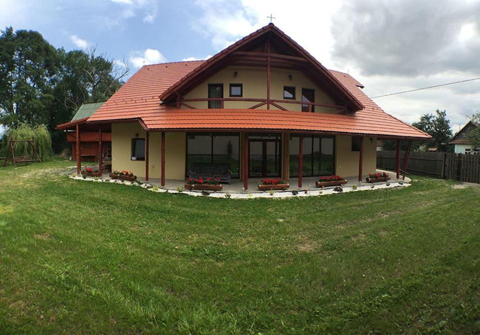 una casa con techo naranja en un campo verde en Fűzfa, en Miercurea-Ciuc