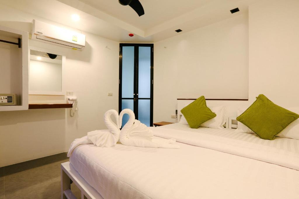 twee bedden in een kamer met groen en wit bij Good Place in Ko Tao