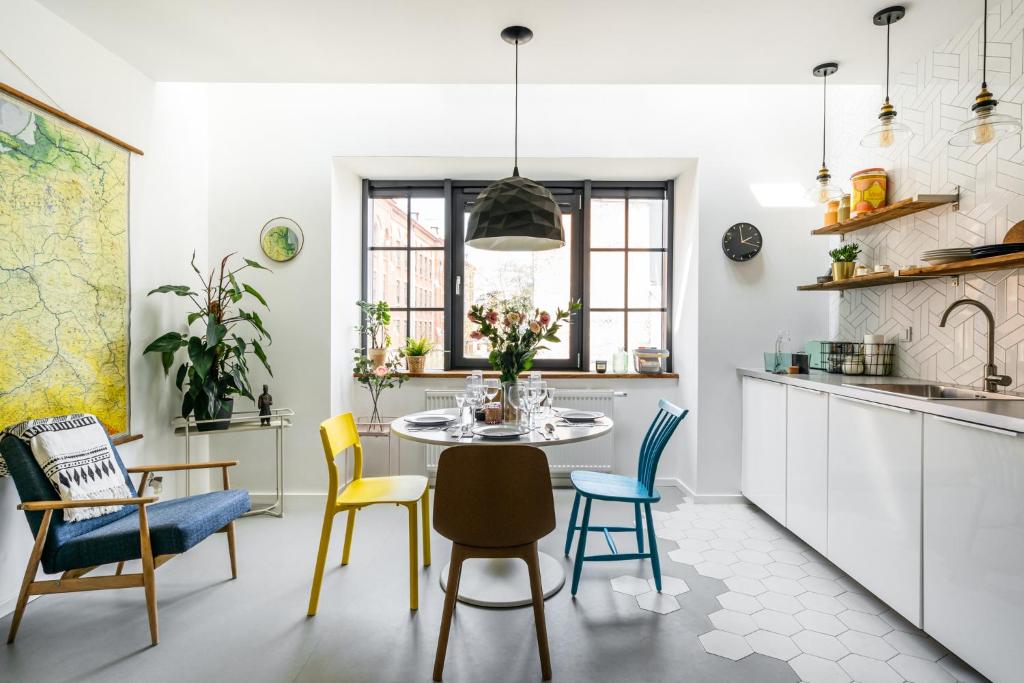 a kitchen and dining room with a table and chairs at Urban Loft by LoftAffair in Kraków