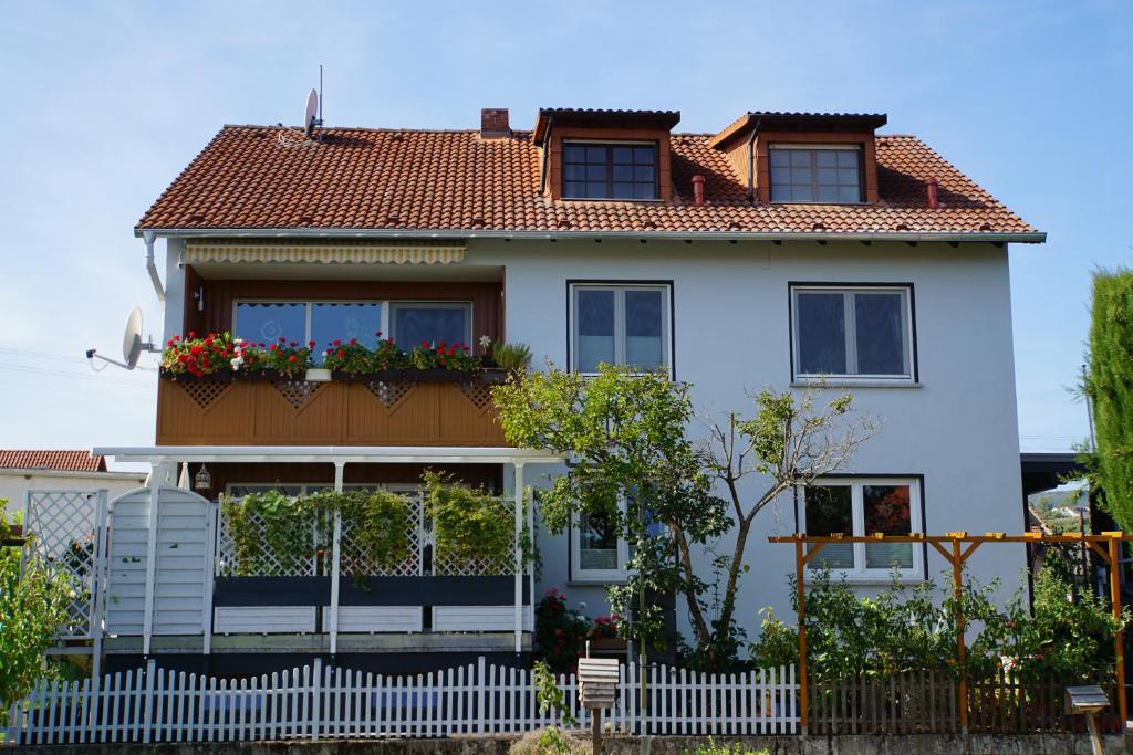 uma casa branca com uma cerca à frente. em Ferienwohnung Knittel em Kallstadt