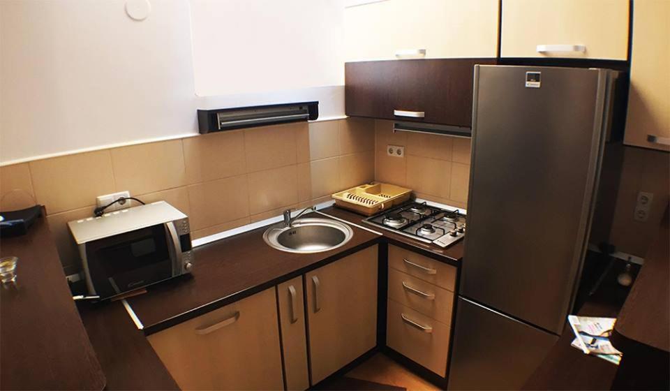 eine kleine Küche mit Spüle und Kühlschrank in der Unterkunft Csengettyűs in Siculeni