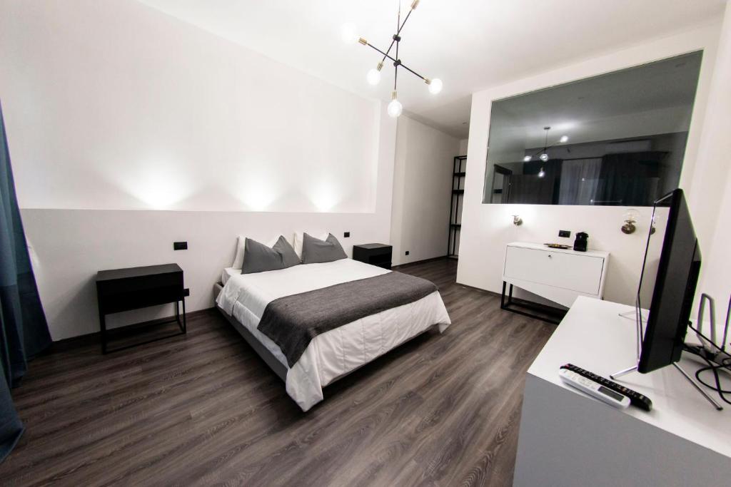 a bedroom with a bed and a desk and a mirror at Margot Fiera Verona in Verona