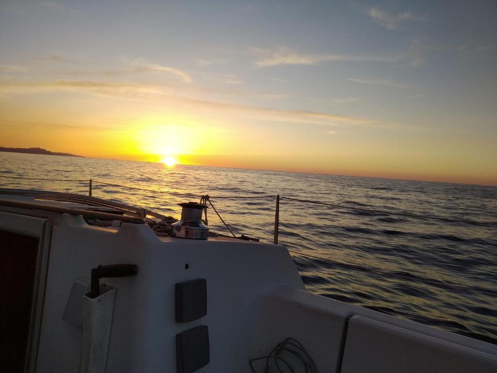 a boat in the ocean with the sunset in the background at Inolvidable experiencia en un velero de 11 metros! in Zumaia