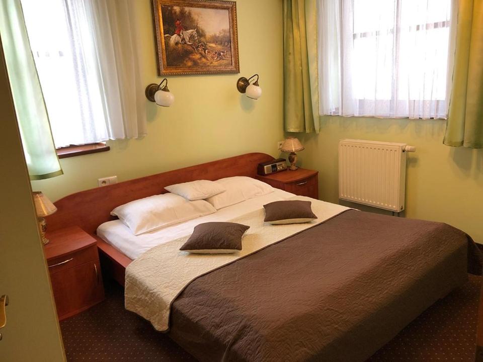 シュチェチンにあるホテル レスタウラツィア ポザムチェのベッドルーム1室(大型ベッド1台、枕2つ付)