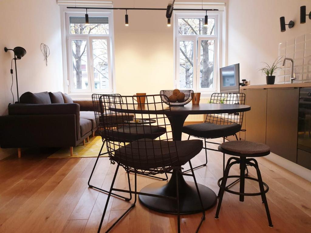 uma cozinha e sala de estar com uma mesa e bancos em Zagreb Centar Apartments em Zagreb