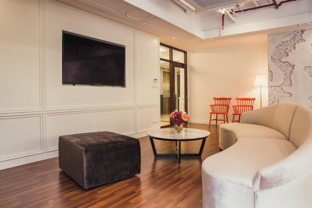 A lounge-like common area with a curved sofa, television and small café table.