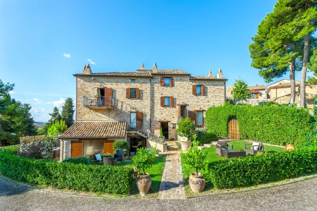 a large stone house with plants in front of it at Mons Major Relais in Montemaggiore al Metauro