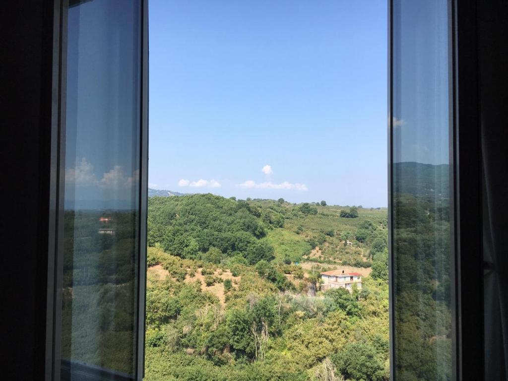 uma janela com vista para uma montanha em Bel appartement dans la campagne étrusque em Vignanello