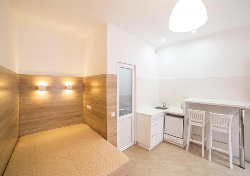 1 dormitorio con cama, escritorio y lavamanos en Smart-апартаменти в центрі Львова, en Leópolis