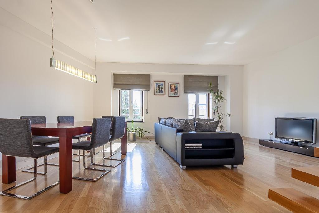 uma sala de estar com uma mesa de jantar e uma televisão em Forum by Home Sweet Home Aveiro em Aveiro