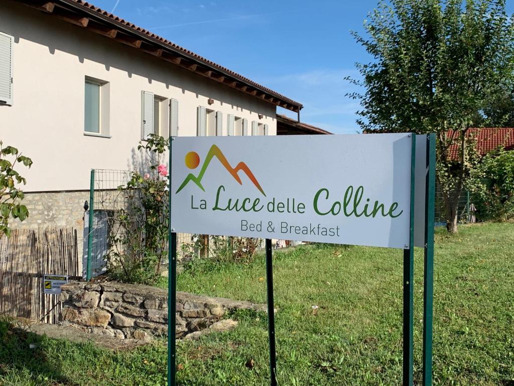 um sinal na relva em frente a uma casa em La Luce delle Colline em Serravalle delle Langhe