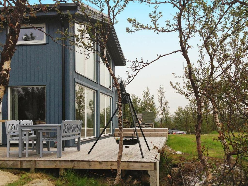 un porche de una casa con 2 sillas y un columpio en 6 person holiday home in Kvalsund en Repparfjord