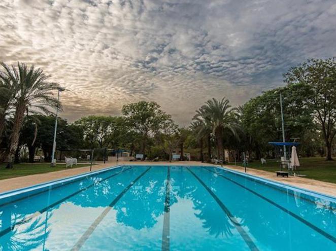 uma grande piscina azul com um céu nublado em Kalia Kibbutz Hotel em Kalia