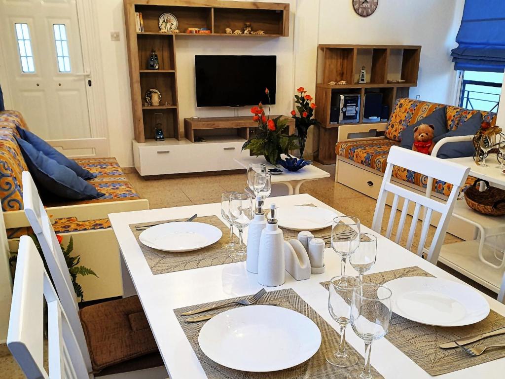 a dining room and living room with a white table and chairs at EasyStay Two Bedroom Apartment in Larnaka