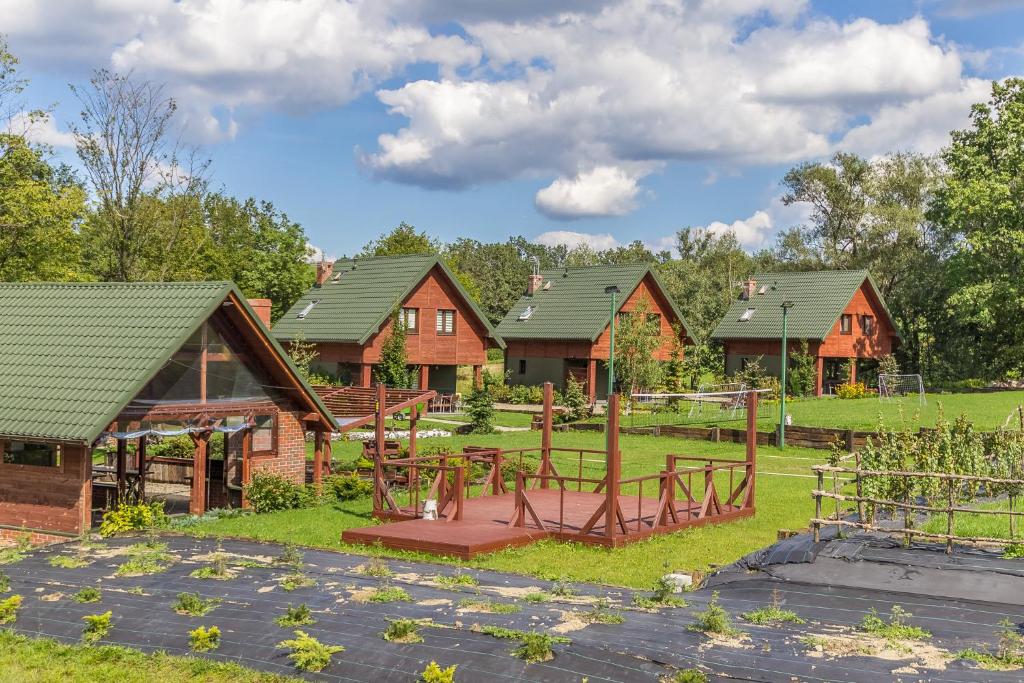 a group of houses with a playground in the yard at Przystanek Zapotocze in Słopnice