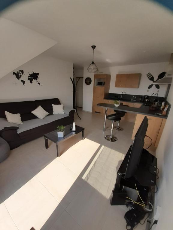 a living room with a couch and a desk at Appart. sur Caen avec Garage et Wifi. in Caen