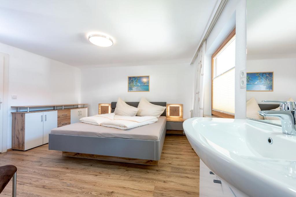 a bathroom with a bed and a tub and a sink at AlpenLiving in Mayrhofen