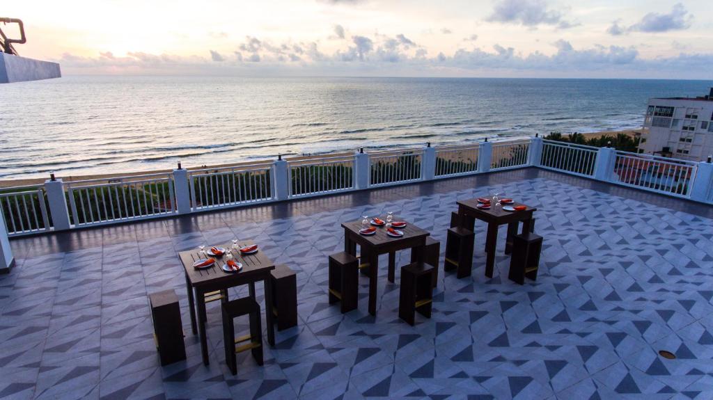 two tables on a balcony with a view of the ocean at Ruvisha Beach Hotel in Negombo