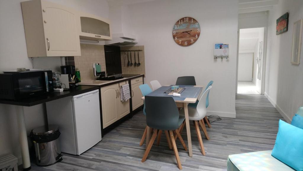 a kitchen with a table and chairs in a room at Appartement Arc en Ciel in Châtelaillon-Plage