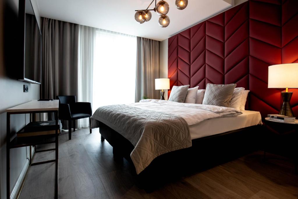 1 dormitorio con cama grande y pared roja en Midtown Hotel en Reikiavik