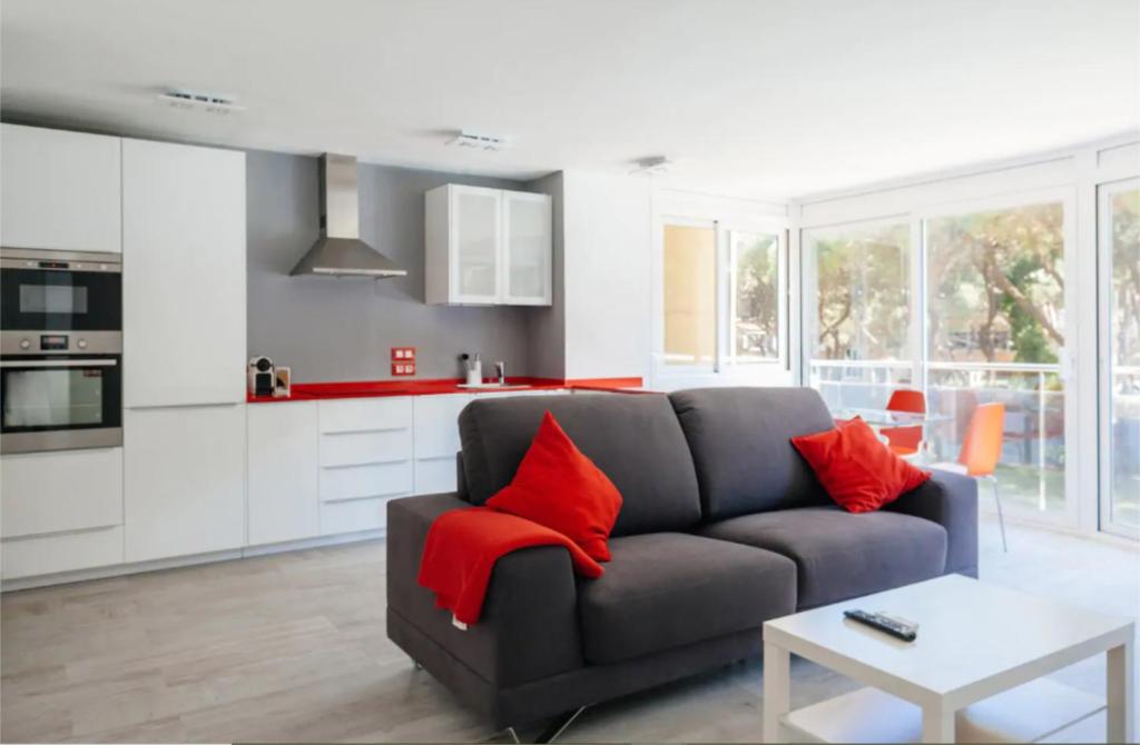 a living room with a gray couch and red pillows at Pine Paradise by Seasidehomes in Gavà