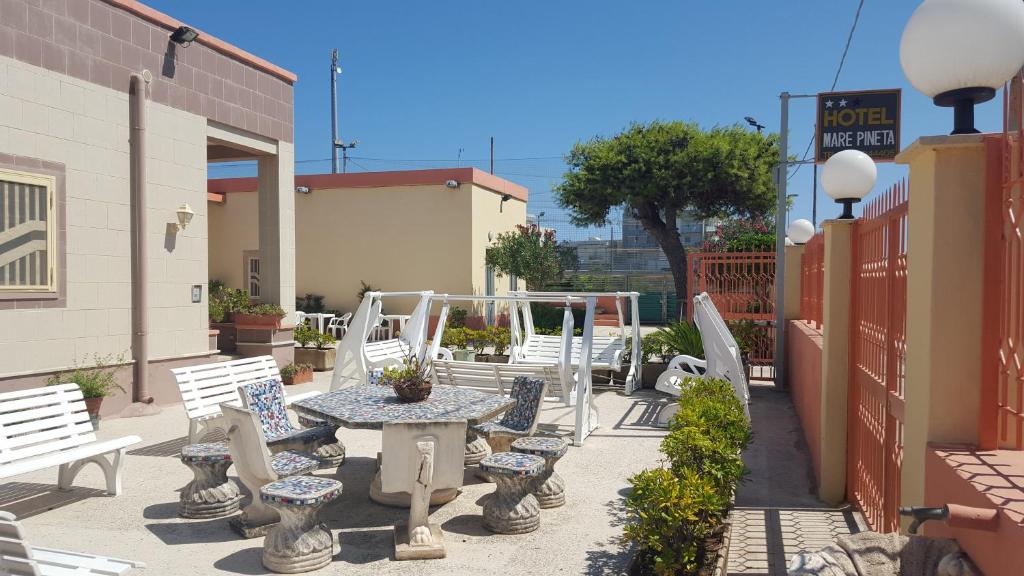 un patio con bancos, mesa y sillas en HOTEL MARE PINETA en Bari