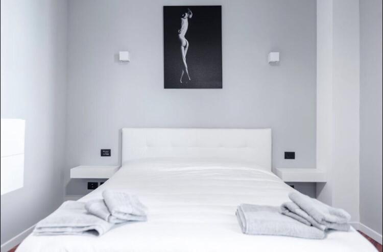 um quarto com uma cama branca com duas toalhas em Le residenze dell'Adda em Cassano dʼAdda