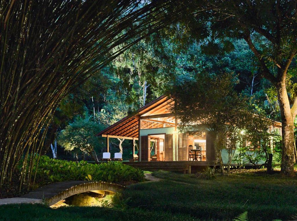 ein kleines Haus in einem Wald mit einer Brücke in der Unterkunft O Sitio - Ilha Grande in Abraão