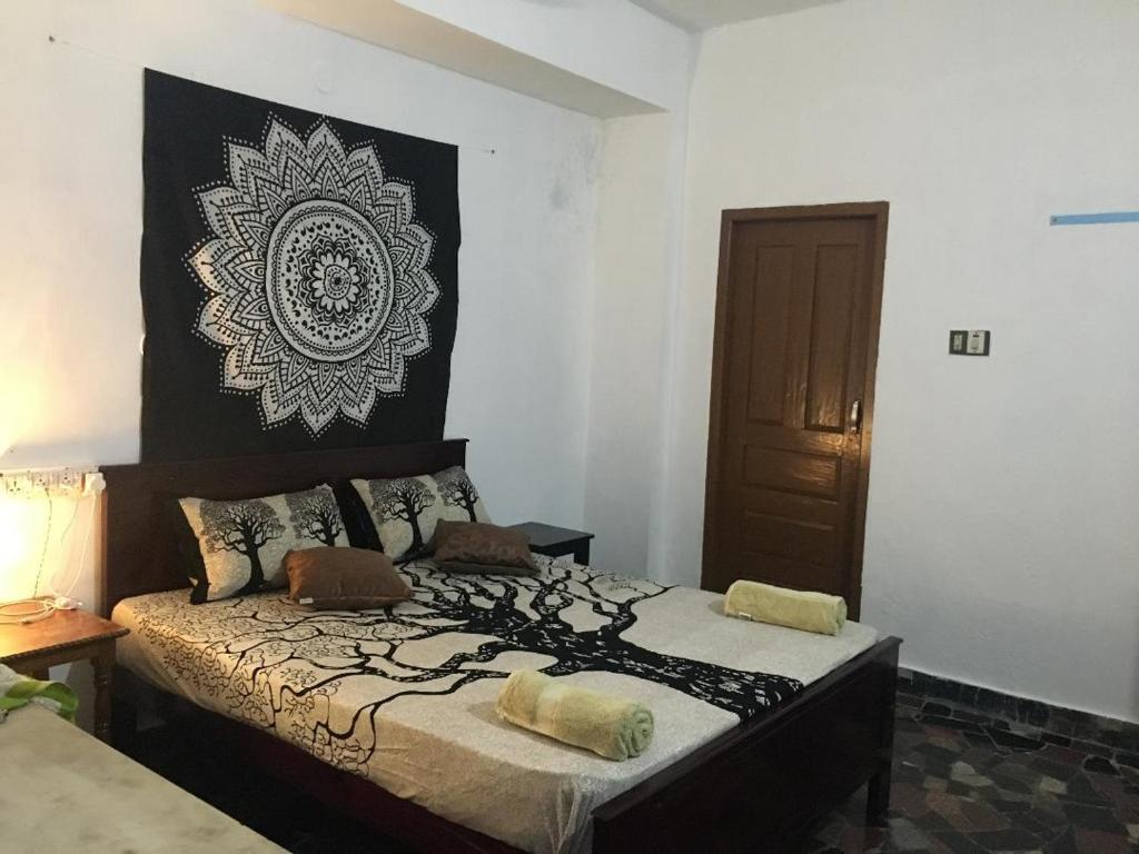 a bedroom with a bed with a large picture on the wall at Zen House in Kovalam