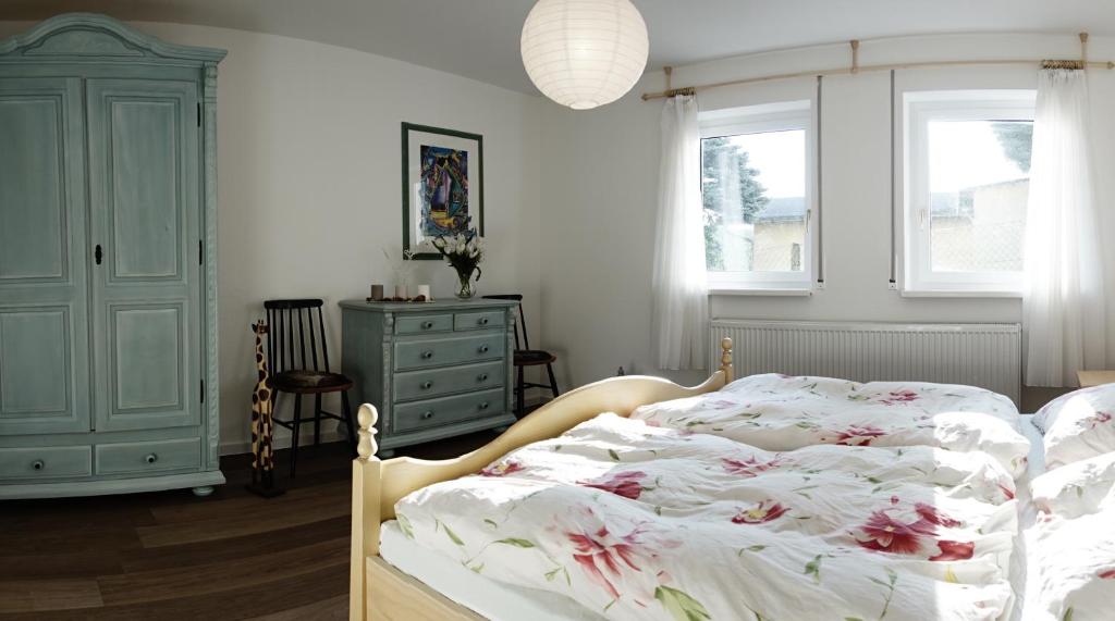 a bedroom with a bed and a dresser and windows at Wanderlust - Thüringer Wald, Rennsteig, Finsterbergen in Friedrichroda