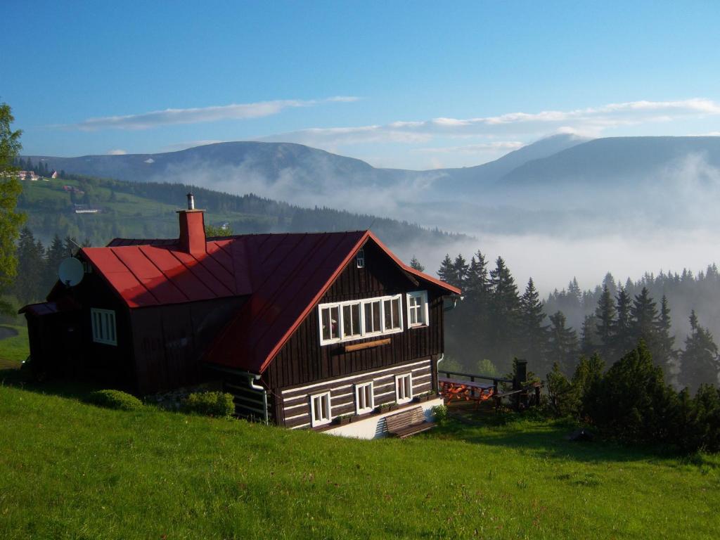 een huis op een heuvel in een veld bij Pension Skalicky in Pec pod Sněžkou