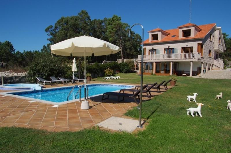 a house with a swimming pool with dogs walking around it at Apartamentos Ay Sálvora in O Grove