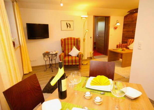 un salon avec une table avec une bouteille de vin dans l'établissement Landhaus Wild, à Riezlern