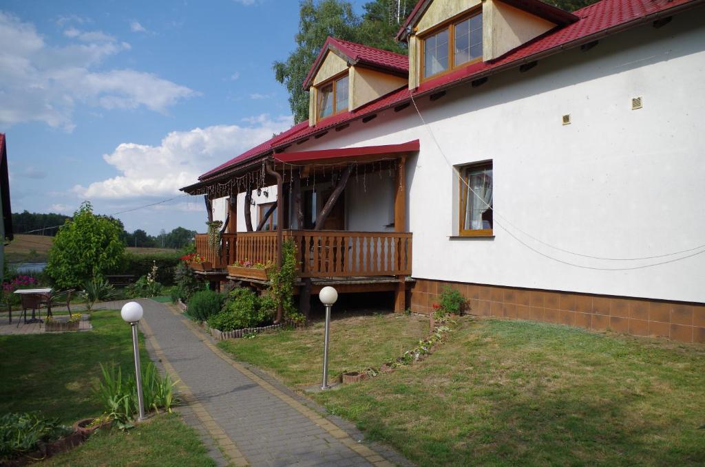 una casa bianca con un portico sul lato di Pensjonat u Kowala a Wałcz