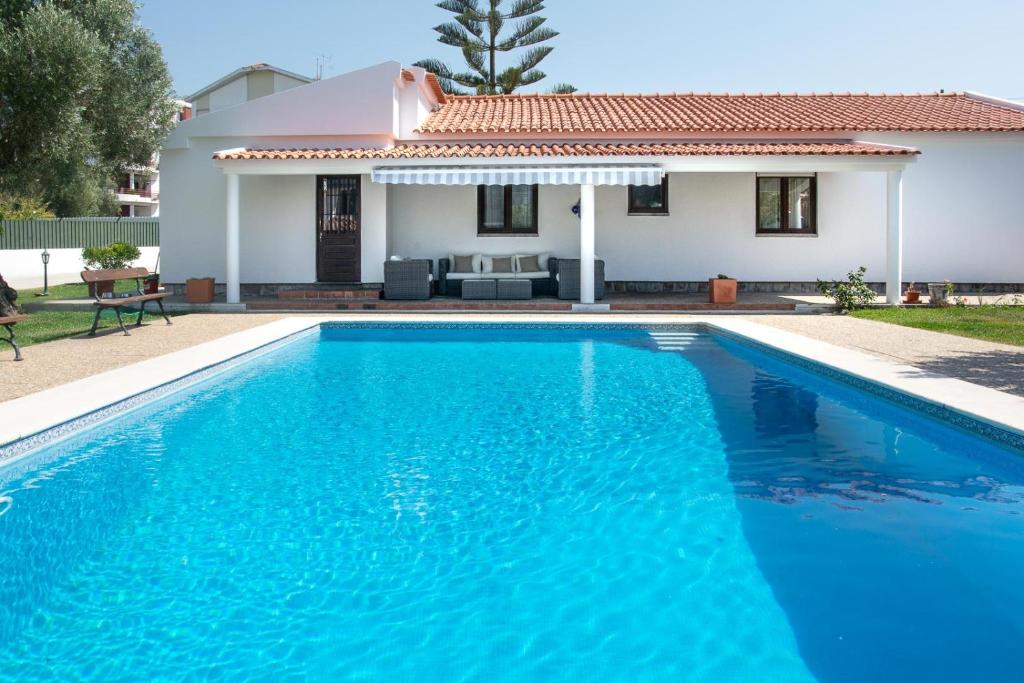 a villa with a swimming pool in front of a house at Casa da Quintinha - Villa with a pool in Sesimbra