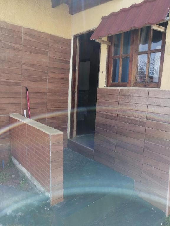 a house with a brick wall and a window at centro piria apartamento 4 in Piriápolis