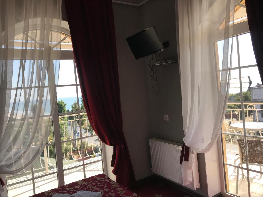 a room with two large windows and a balcony at Hotel Comfort in Vapnyarka
