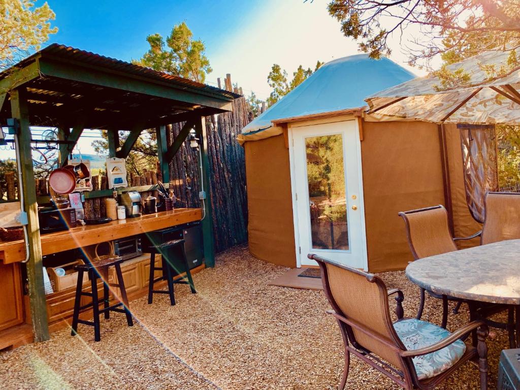 a gazebo with a table and chairs in front of a house at The Yoga Yurta at Sunny Mellow Eco Villa in Tijeras