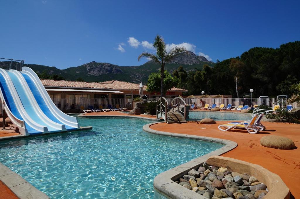 een zwembad met een glijbaan in een resort bij Résidence Les Castors in Calvi